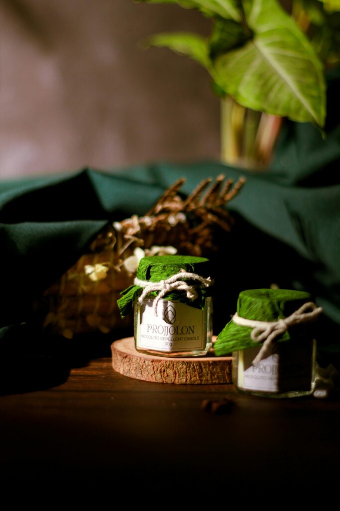 Eco-friendly candles in a rustic setting with lush green leaves, promoting sustainable products.